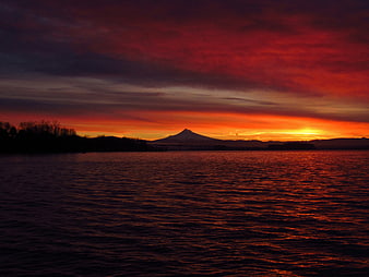 Dramatic Red Sunset Over Lake With Mountain Silhouette