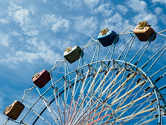 Vintage Ferris Wheel Against Blue Sky with Clouds