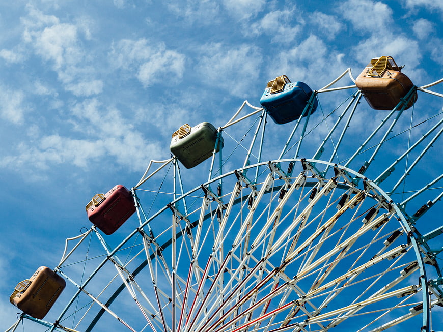 Vintage Ferris Wheel Against Blue Sky with Clouds