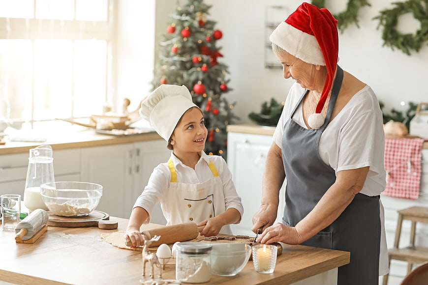 Grandmother and granddaughter baking Christmas cookies in kitchen