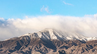 Snow-Capped Mountain Peak Emerging from Clouds