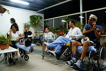Patients in wheelchairs waiting in hospital corridor at night