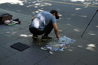 Street artist drawing 3D cartoon character on pavement
