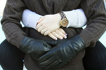 Close-up of woman's hands with watch and leather gloves
