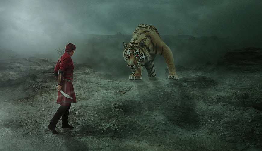 Fantasy warrior woman facing a menacing tiger in a dark, misty landscape