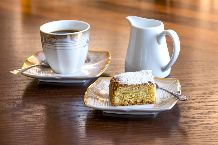 Coffee cup and slice of cake on wooden table