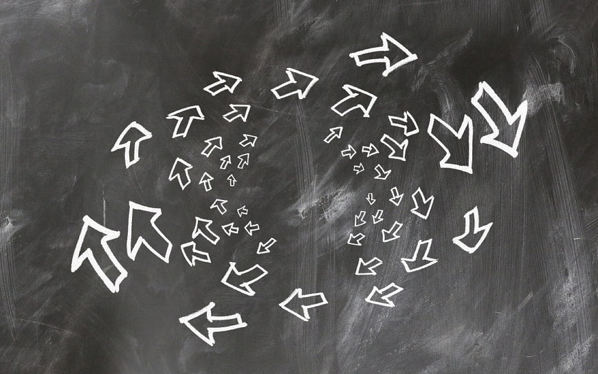 Hand-drawn white chalk arrows on a dark blackboard background