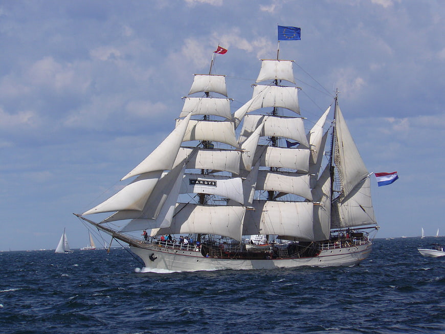 Three-masted barque sailing on the ocean with full sails