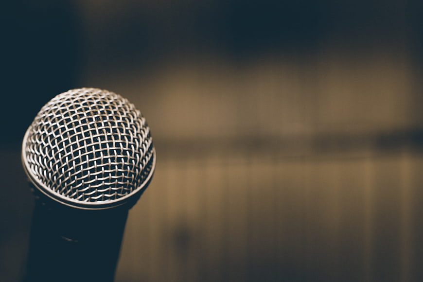 Close-up of silver microphone on stage with blurred background