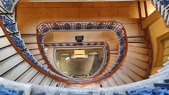 Top-down view of ornate spiral staircase with blue railings