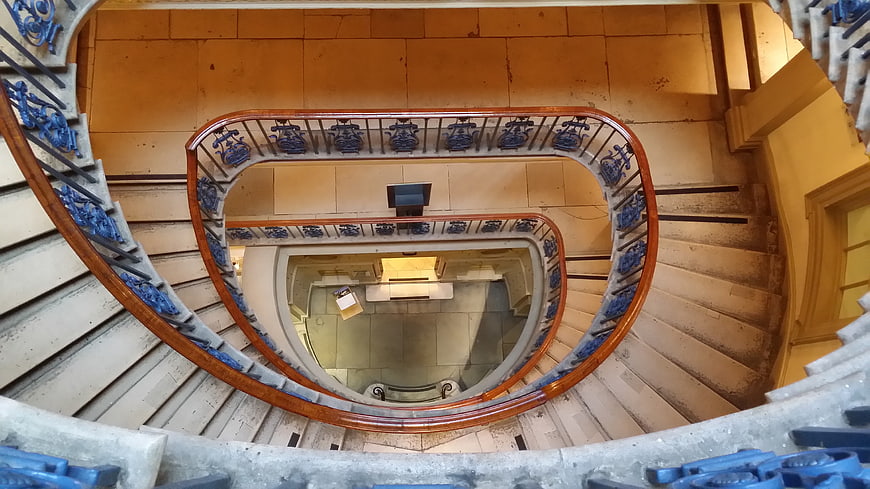 Top-down view of ornate spiral staircase with blue railings