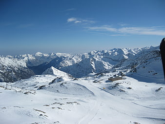 Snowy Mountain Landscape with Ski Slopes and Blue Sky