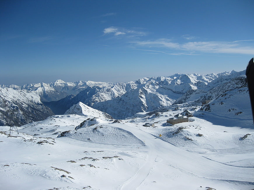 Snowy Mountain Landscape with Ski Slopes and Blue Sky
