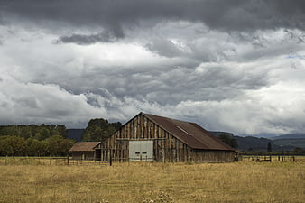 Weathered wooden barn under dramatic cloudy sky
