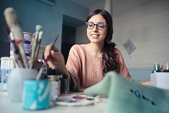 Smiling female artist painting in creative studio workspace