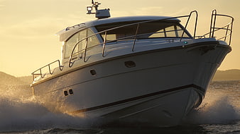 White Motor Yacht Cruising On Water At Golden Hour