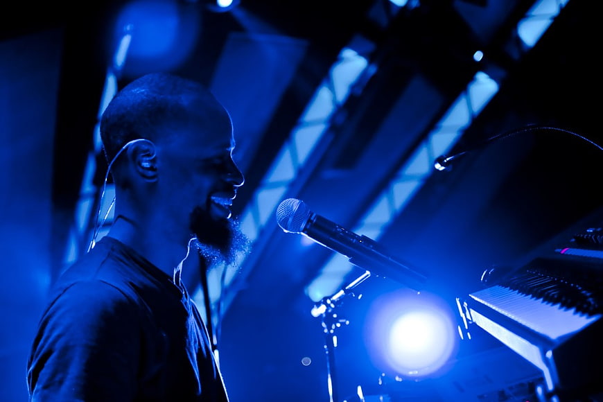 Male Musician Singing and Playing Keyboard on Stage