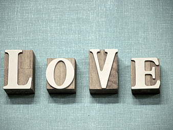 Wooden blocks spelling LOVE on blue textured background