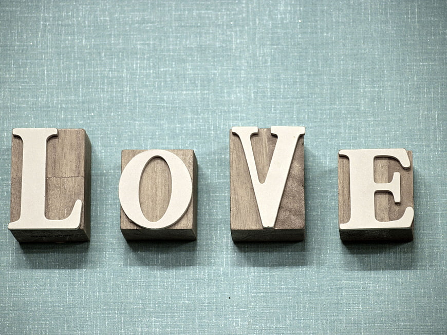 Wooden blocks spelling LOVE on blue textured background