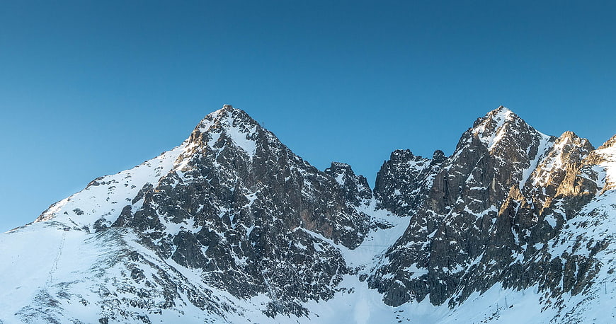 Snowy mountain peaks against a clear blue sky