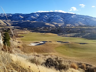 Golf course landscape with snow-capped mountains and residential homes