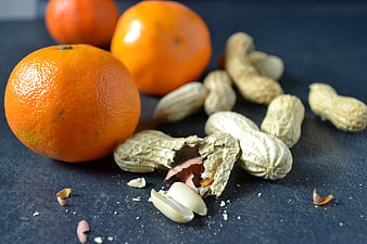 Fresh Oranges and Peanuts on Dark Slate Background