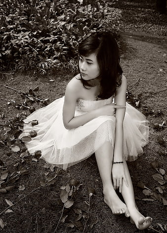Woman in White Dress Sitting on Grass in Sepia Tone