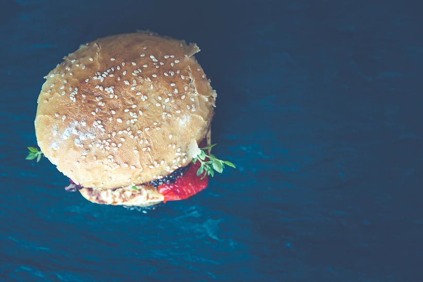 Delicious Hamburger on Blue Background with Copy Space
