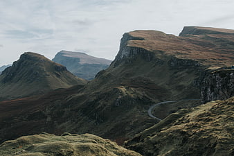 Dramatic mountain landscape with winding road and overcast sky