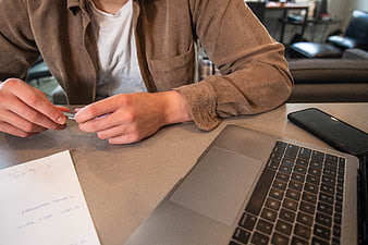 Man working at desk with laptop and smartphone