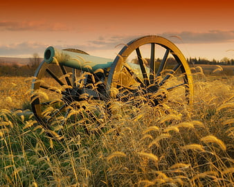 Historic Civil War Cannon in Golden Field at Sunset