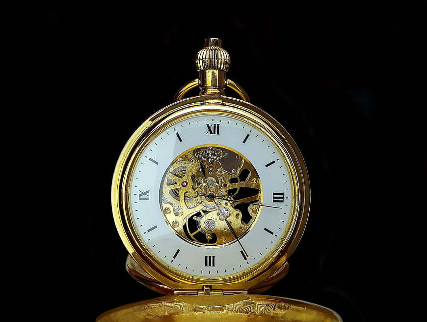 Gold Skeleton Pocket Watch on Black Background