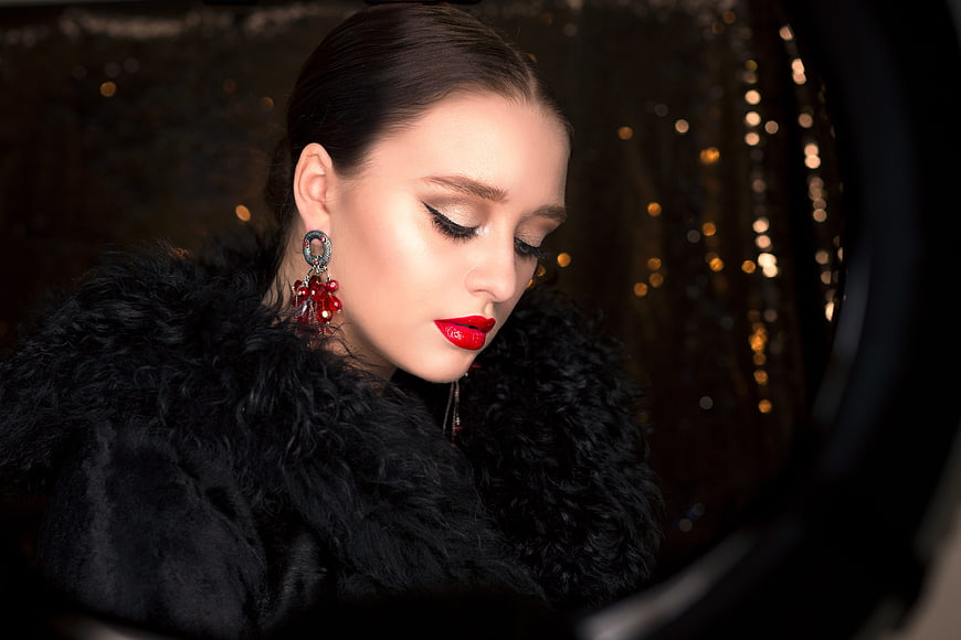 Glamorous woman with red lips and fur coat in studio