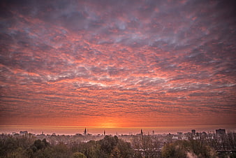 Vibrant pink and orange sunrise over Groningen city skyline