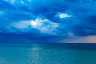 Dramatic Blue Stormy Sky Over Calm Ocean Horizon