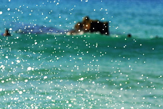 Abstract turquoise ocean water with sparkling bokeh and blurred background
