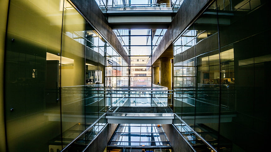 Modern glass atrium with geometric architecture and reflections