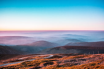Winding Mountain Road Through Misty Highland Valley at Sunrise