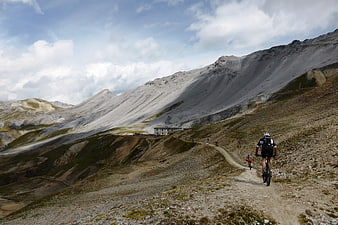 Mountain bikers riding on a rugged alpine trail in Stelvio National Park