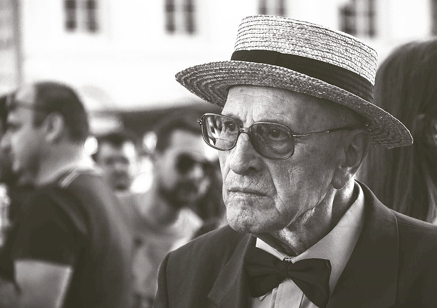 Portrait of elderly man in straw hat and bow tie