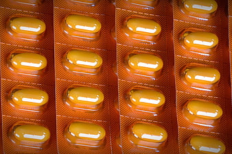 Close-up of yellow capsules in orange blister pack