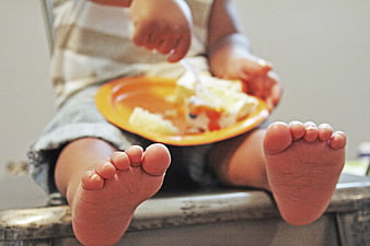 Close-up of baby feet while eating cake
