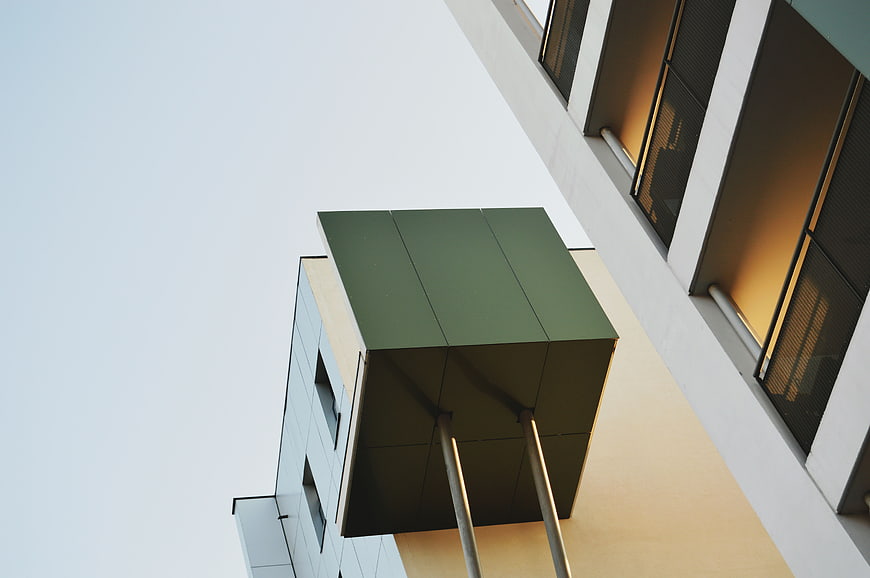 Low angle view of modern green cube architecture