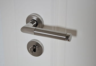Stainless Steel Door Handle And Key Lock On White Door
