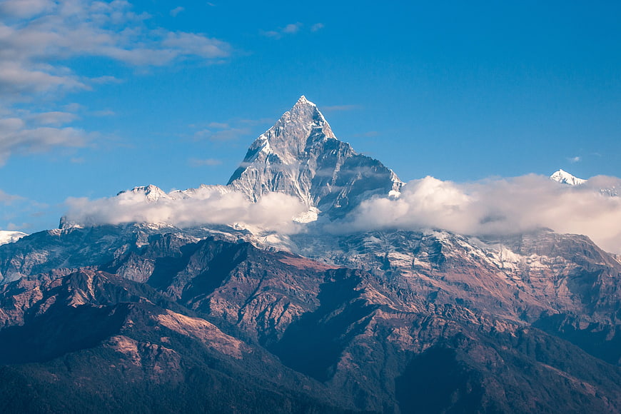 Majestic Snow-Capped Mountain Peak Rising Above Clouds