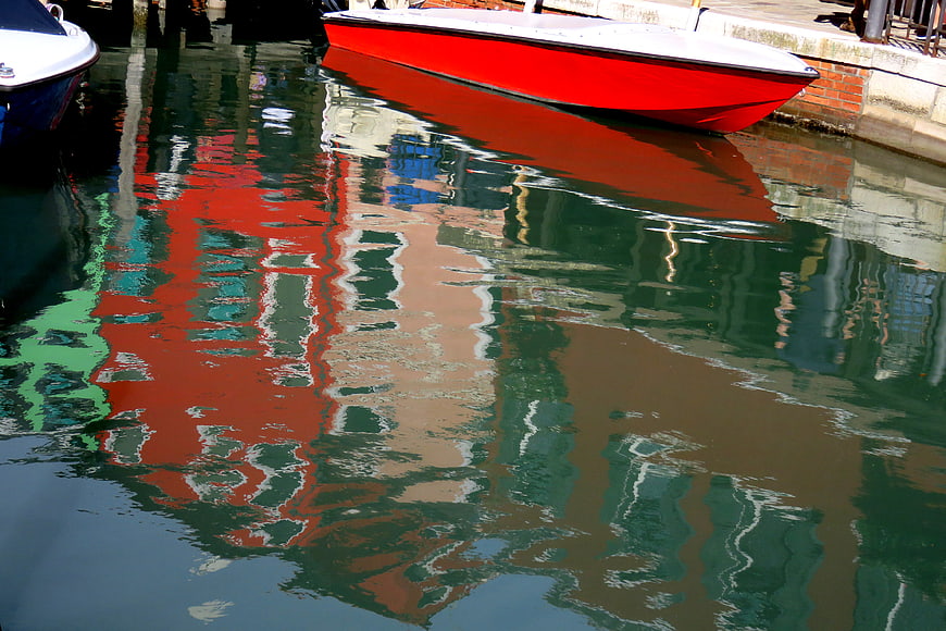 Red boat reflection in Burano canal water