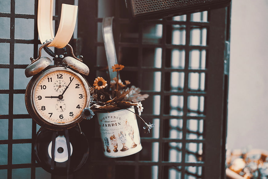 Vintage Alarm Clock and Dried Flowers on Metal Grid