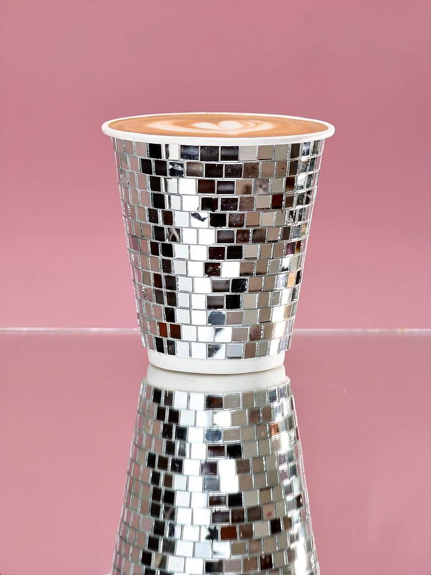 Latte Art in Silver Mosaic Cup on Pink Background
