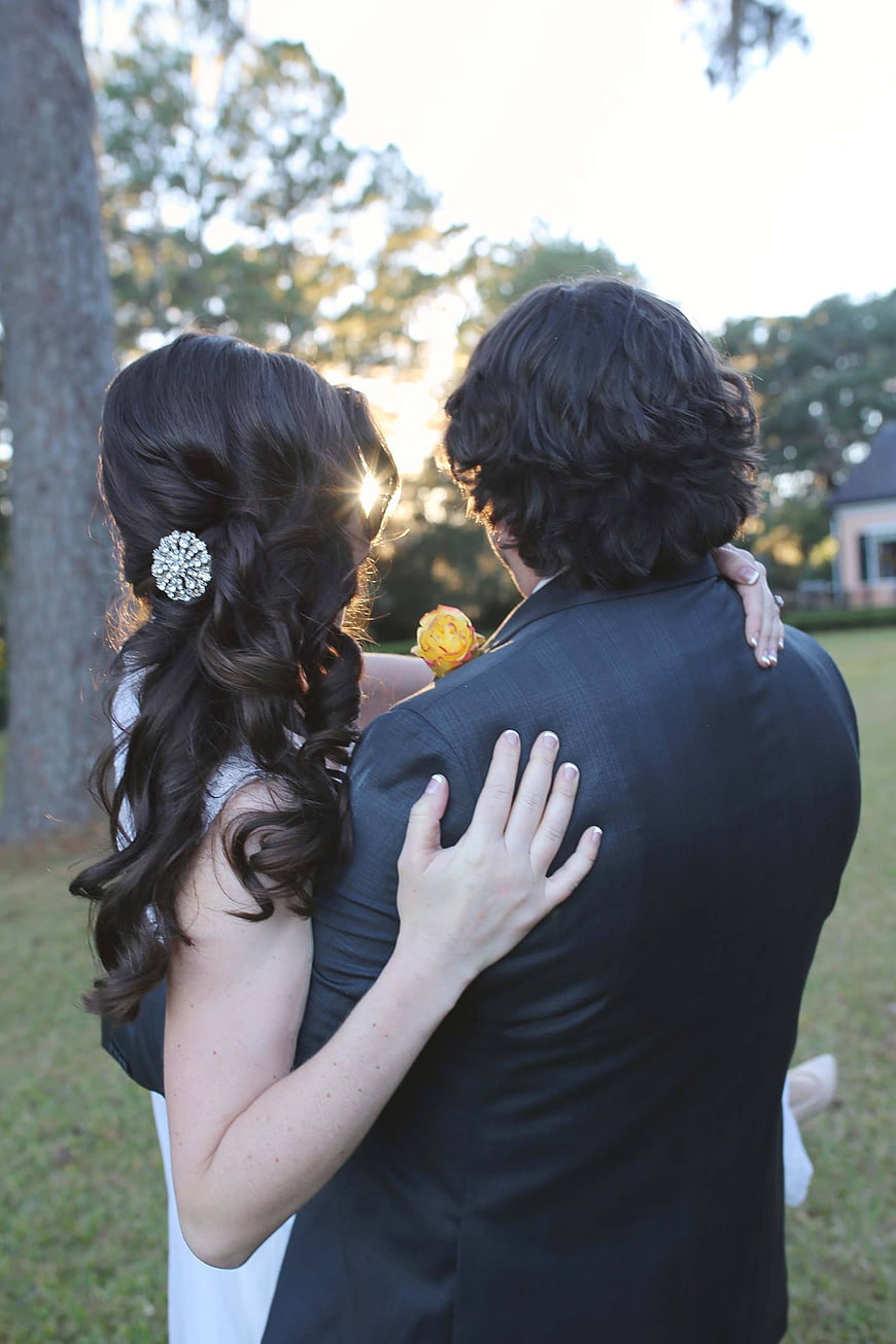 Bride and Groom Embracing from Behind at Sunset