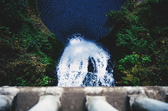 Aerial View of Waterfall Cascading into Deep Blue Pool